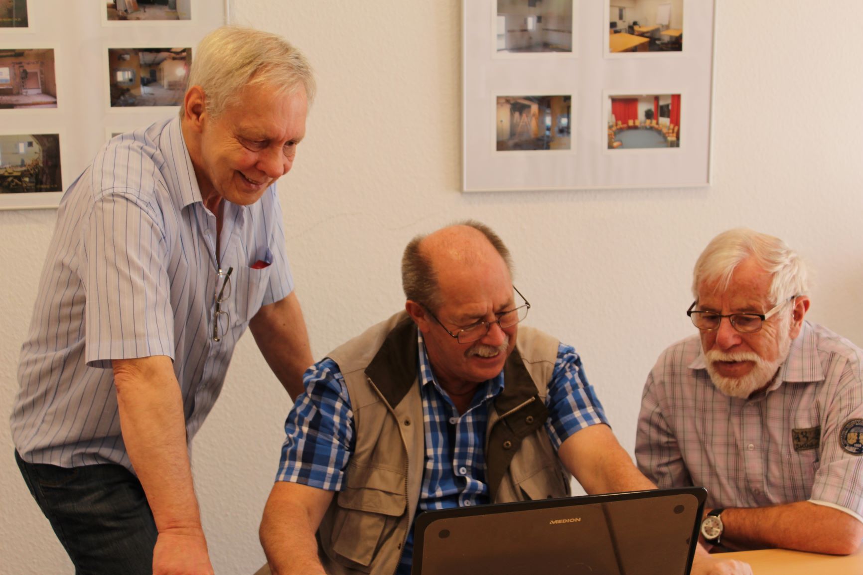 Drei Senioren schauen auf ein LAptop