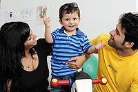 Eltern mit Kind auf Schaukelpferd