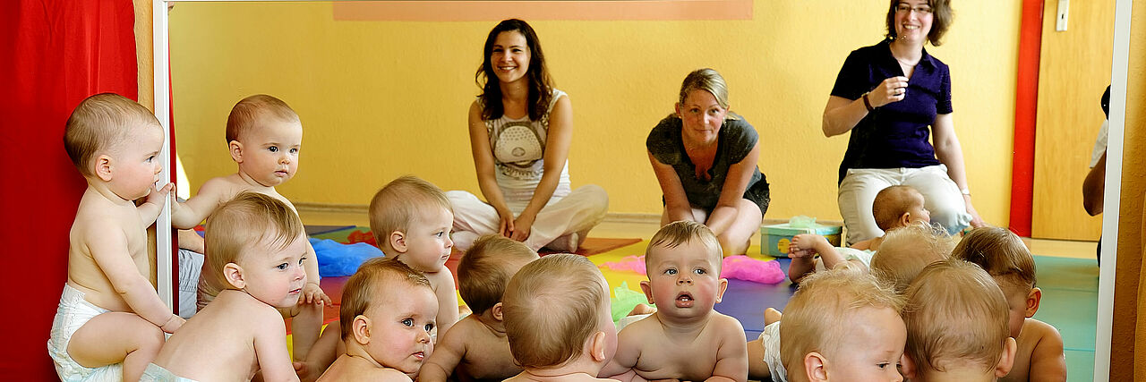 mehrere Babys auf Teppich bei Familienbildung