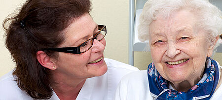 Pflegerin mit Seniorin