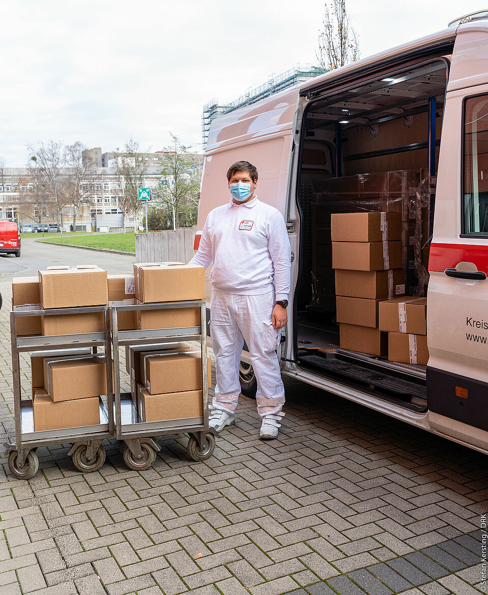 Mann mit Maske und Medikamententransport