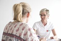 Betreuerin unterhält sich mit junger Frau