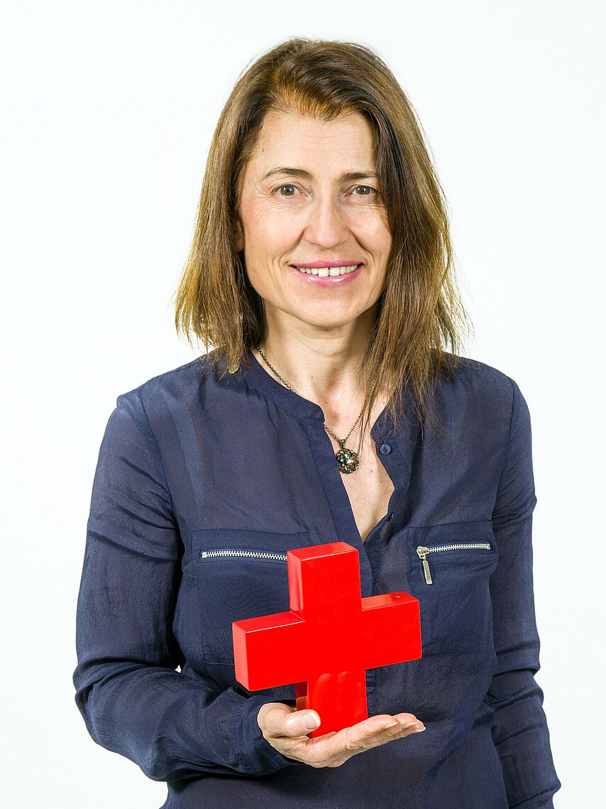 Frau hält Rotes Kreuz in der Hand 