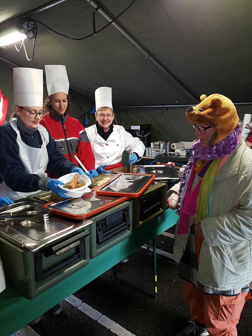 Weihnachtsessen für Obdachlose. Eine obdachlose Frau holt sich ihr Essen ab